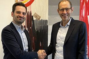 Handshake from Prof. Dr. Johannes Wohlfart and WiSo Dean Prof. Ulrich Thonemann, Ph.D. in front of an abstract painting in the Nouveau Realisme style